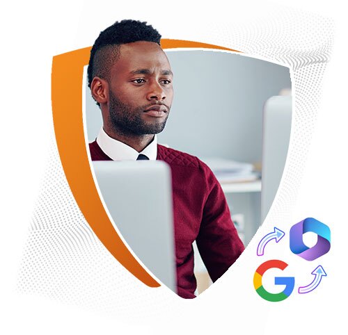 A man in a maroon sweater and white shirt works at a computer in an office setting. The image is framed within an orange and white shield shape, with Google and Microsoft 365 logos showing circular arrows, symbolizing data or platform migration.